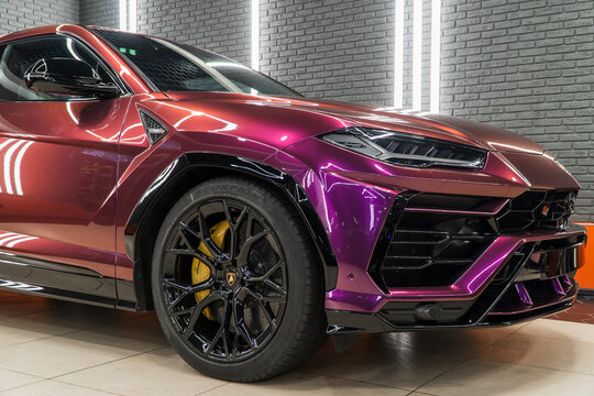 The Lamborghini Urus in violet-chameleon PPF is a high performance luxury SUV manufactured by Italian automobile manufacturer. Violet chameleon color Urus in the tuning studio. Wrapping car.