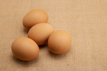 Pile of chicken egg on burlap cloth background