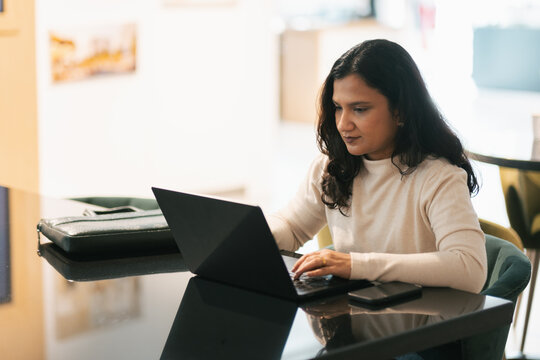 Business consultant working in collaborative office lounge, woman entrepreneur on laptop, co-working spaces for start ups 