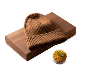 Ribbed knit cap sits on wooden block next to small yellow flower