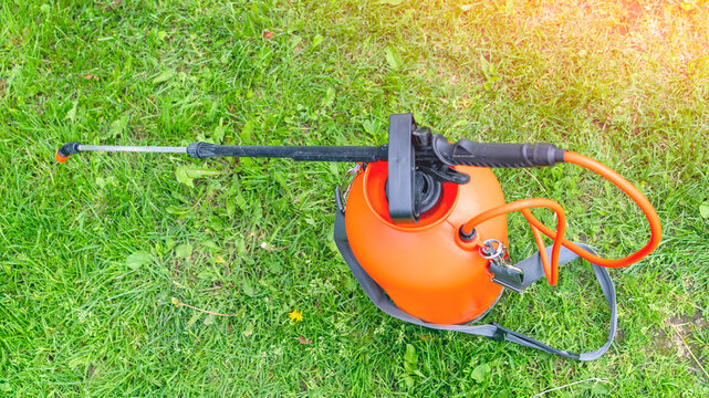 Lawn sprayer, lawn care, watering and fertilizing, gardening, landscaping, gardening equipment and tools, country plot or park area. High quality photo