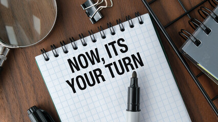 Now it's Your Turn text, inscription, phrase written in a notebook that lies on wooden table with...