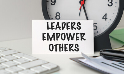 A white clock sits on a desk with a white card that says Employee Assistance Program