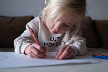 Preschool child doing homework and practicing writing skills, early education concept.