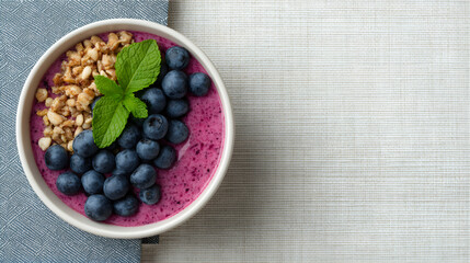 Healthy smoothie bowl topped with blueberries and granola.