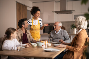 Multi-generational family having fun during lunch at home