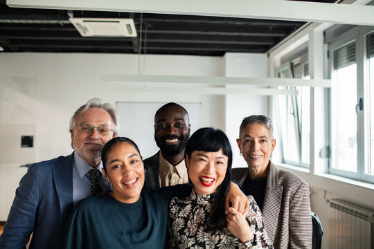 Adult and senior team smiling together in modern office