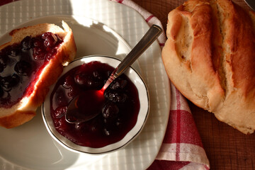 Toast with Cherry Jam and Spoon on White Plate, Sunlit Minimal Breakfast Flat Lay