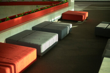 Interior with ottomans. Window light on furniture. Seating.