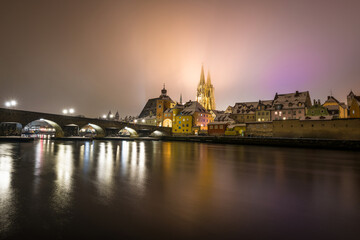 Regensburg mit Domblick auf Dom Sankt Peter und Steinerne Br&uuml;cke nachts im Winter mit Schnee und Beleuchtung, Deutschland