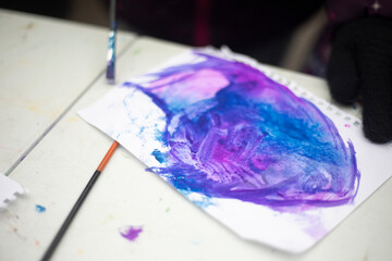 Drawing lesson. Paint stain. Purple spot painted on a sheet.