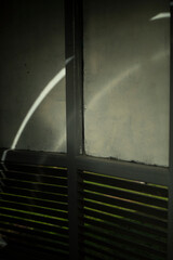 Wall in a pedestrian crossing. Grey wall with steel blinds. Light on the surface.