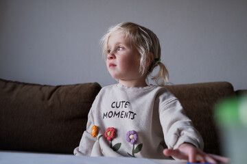 Frustrated child feeling disappointed over failure, sitting by the window at home.