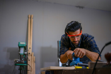 Carpenter is working at workshop.