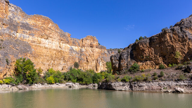 Limestone cliffs of Hoces del Rio Duraton canyon with river and green vegetation, Segovia Spain