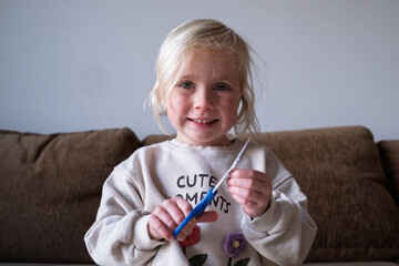 Happy preschool child developing fine motor skills using scissors, creative art lesson.
