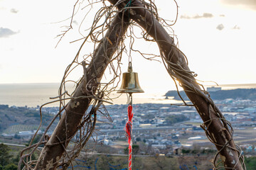 海を望む高台に設置された金の鐘と夕暮れの絶景