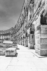 Naklejka premium The Roman amphitheatre in Pula, Croatia, stands as a remarkable example of ancient architecture. Constructed of stone, its impressive arches and columns tell stories of a vibrant history.