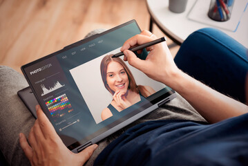 Photo retoucher working on 2-in-1 laptop