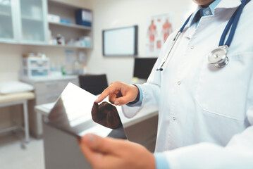 Male doctor with tablet working in the office