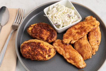 barbecue cchicken tenders  with potato skins  and cole slaw