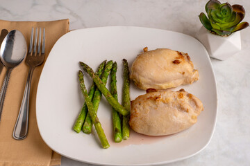 baked hicken thighs served with asparagus