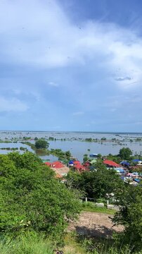 Viewpoint of a flooded fishing village near the Krahom Temple, Cambodia. From the mountain Krahom (Pnom Krom) overlooking the lake Tonlesap. Houses are built on high stilts. Rainy season. 4К
