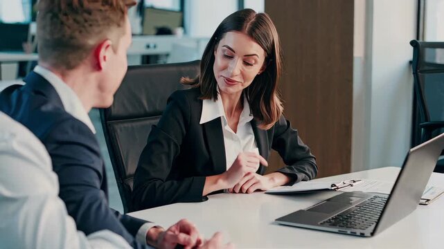 A cheerful female bank employee sitting at a desk, having a meeting with two clients, smiling and making eye contact, professional office setting, documents on the table