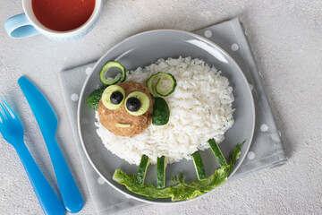 Creative breakfast for child - rice, cutlet, cucumber and olives in the shape of cute sheep