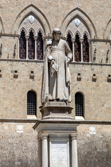 statue of sallustio bandini in the piazza salimbeni in siena tuscany italy sunny day