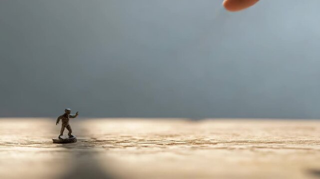 A tiny figurine of a person with the fingertip on top