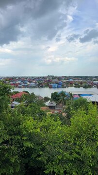 Viewpoint of a flooded fishing village near the Krahom Temple, Cambodia. From the mountain Krahom (Pnom Krom) overlooking the lake Tonlesap. Houses are built on high stilts. Rainy season. 4К