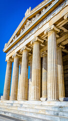 Obraz premium Ancient Greek-style temple with tall columns and intricate sculptures.