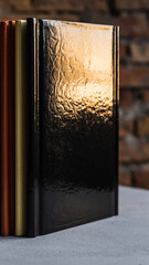 Close-up of a row of hardcover books with textured covers on a table.