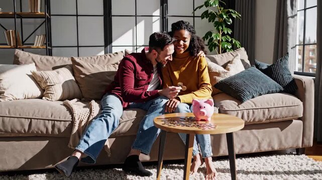 A happy couple sitting together in a living room, smiling while placing coins into a piggy bank, scattered coins on the table, cozy modern home interior in the background