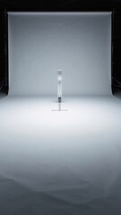 Minimalist white stand with a grid of small black squares on top, in a studio.