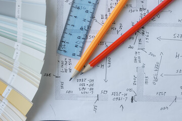 Detailed layout plans with tools for design work on a table in an office setting during the day