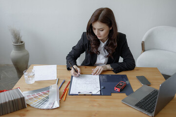 Businesswoman working on project plan at desk in modern office setting during daytime