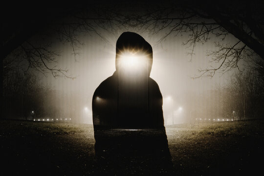 A horror edit of a double expsoure of a ghost like figure. in a park. On a spooky foggy winters night