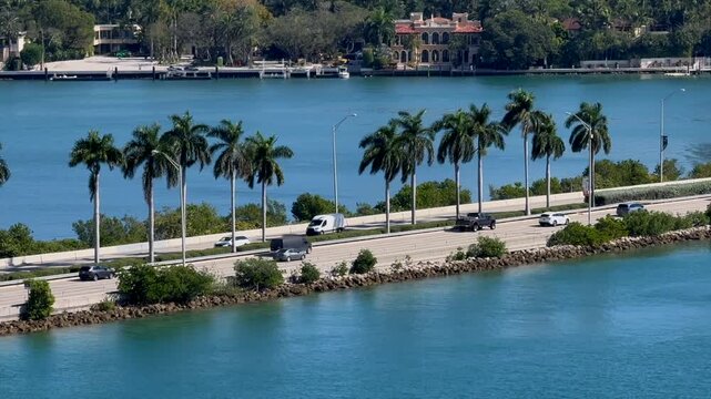 Road with pal trees sorrounded by ocean bay water