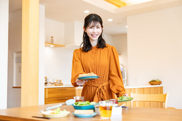 料理を運び、食卓を整えている女性