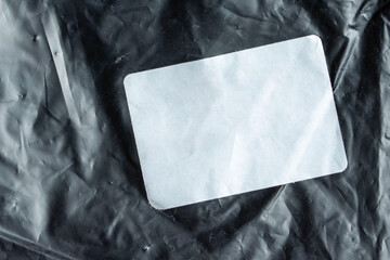 Minimalist black crumpled paper texture background with blank white card for mockup design.