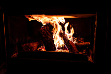 Fireplace with log fire in living room, cozy and warm home	