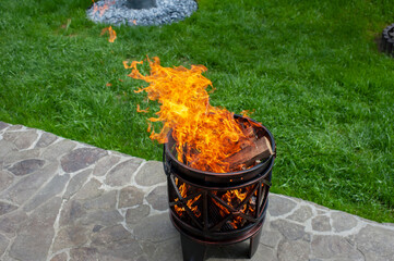 The male hand and warm fireplace with lots of trees ready for barbecue