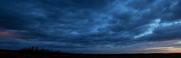 A stunningly beautiful sunset sky and colorful clouds over a field of mown corn.