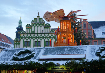 Weimar, Germany, snow covered Christmas market with tree and wooden traditional pyramid