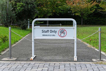 公園や施設の管理通路に設置された「Staff Only（関係者以外立入禁止）」の白いスタンド看板