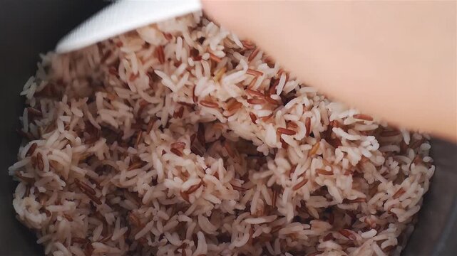 Footage Close up Hand Using White Ladle Scooping Hot Mixed Brown and Jasmine Rice in Electric Rice Cooker for Healthy Meal
