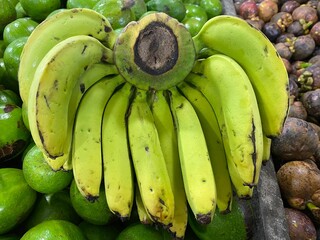 Close up shot of fresh green bananas hanging for sale at a traditional market. Selective focus.