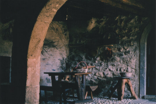 Wooden Table in front of an Ancient Stone House in Cornello dei Tasso Village, Italian Alps, during Late Summer. Beautiful Atmosphere. Camerata Cornello, Bergamo Province, Italy. Film Photography